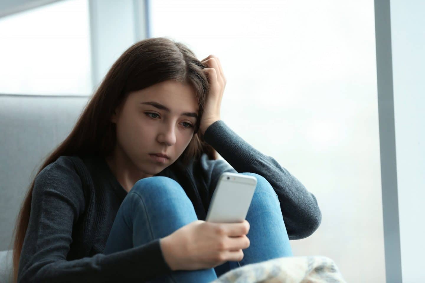 girl looking sad at her phone