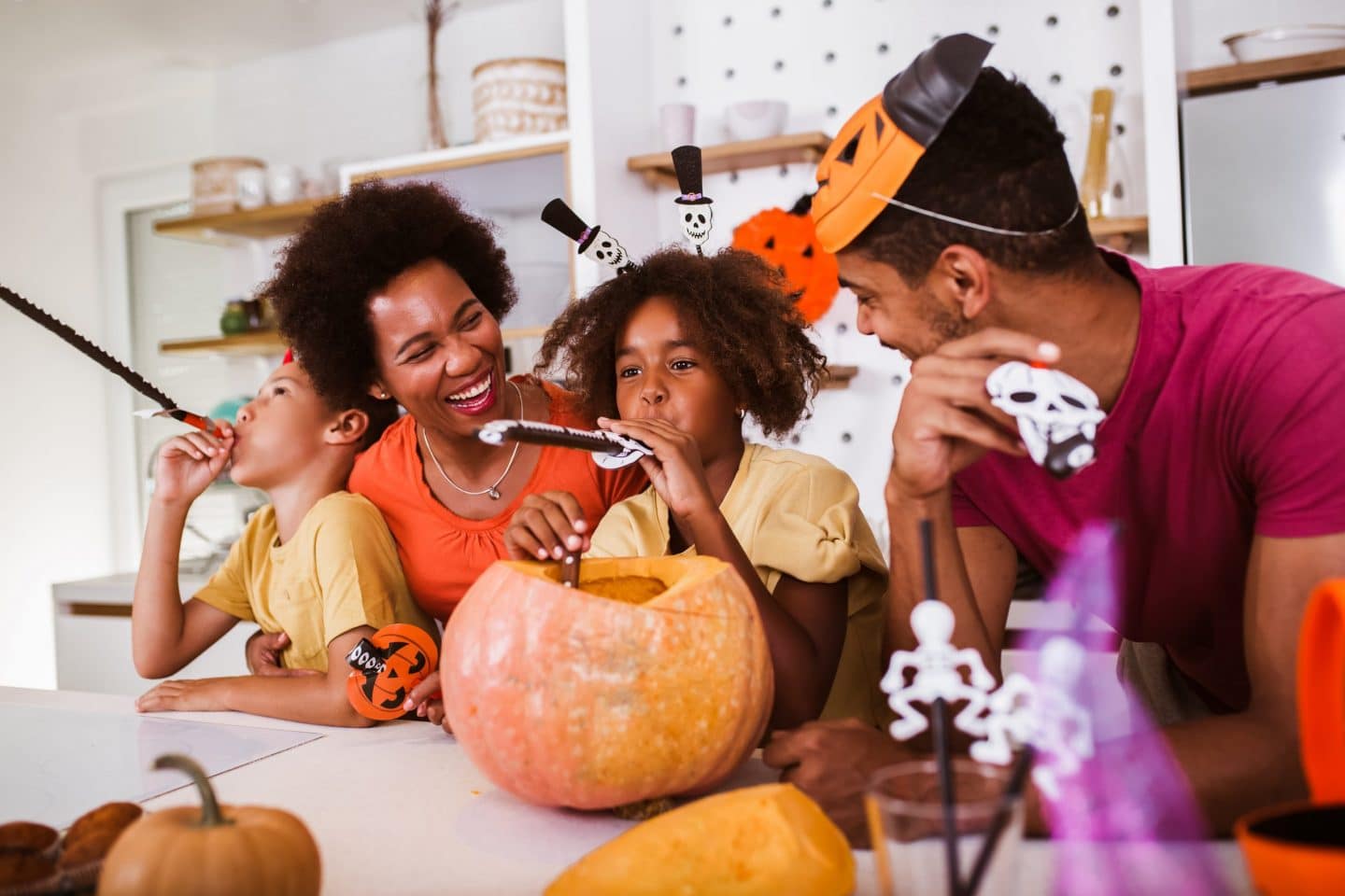 Parents and kids carving pumpkins for Halloween