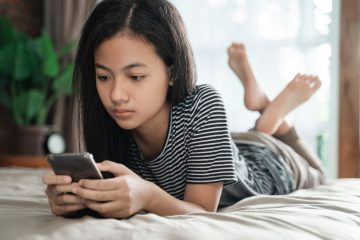 girl laying on bed with phone
