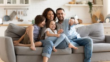 Family on couch looking at a smartphone