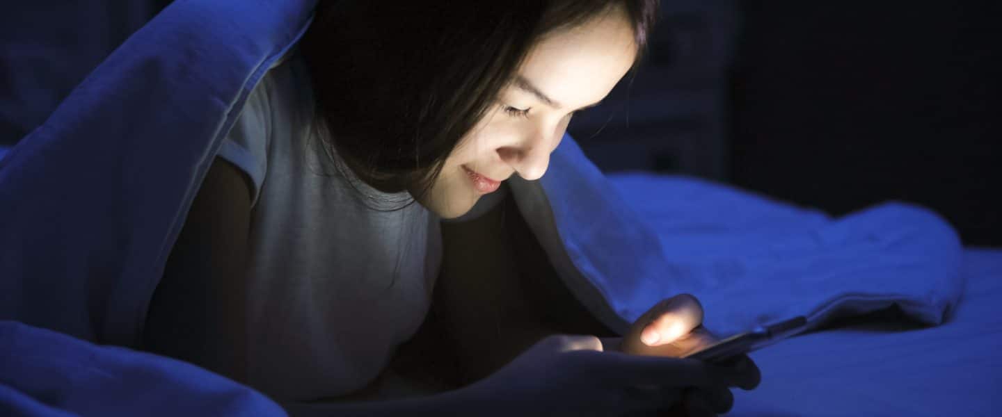 Teen girl looking at finsta and smiling