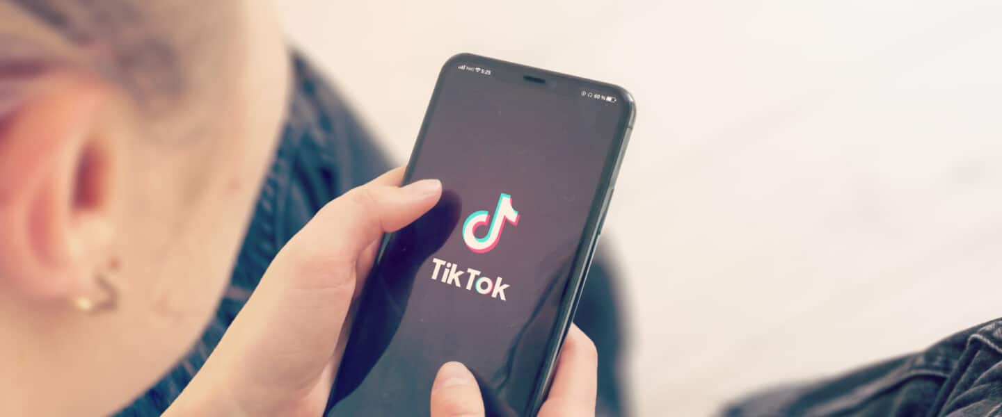 girl holding phone with tiktok app
