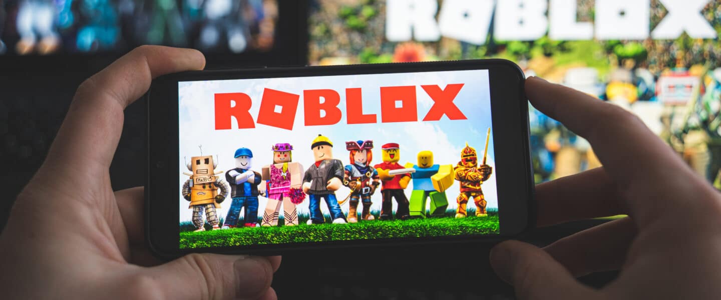 hands holding phone with roblox
