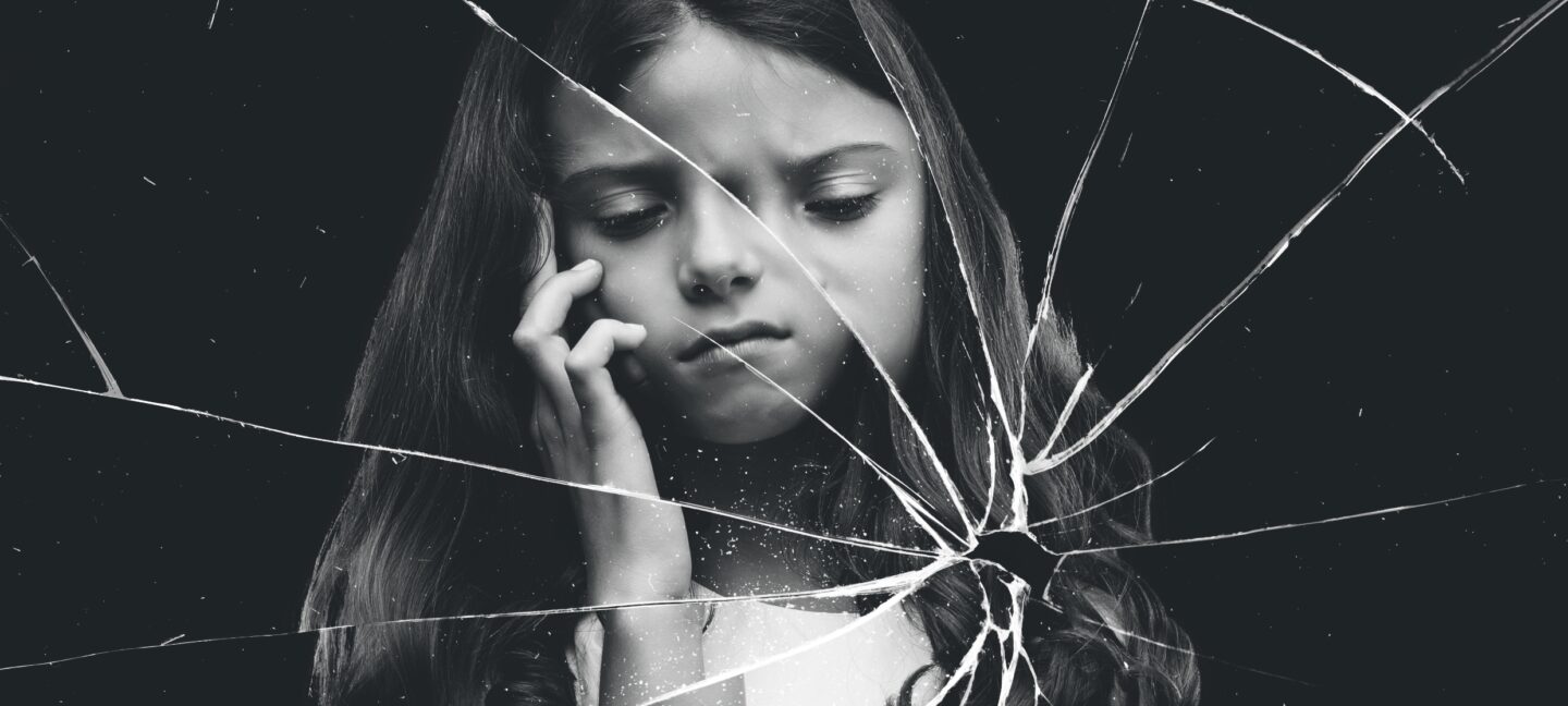 Photo of a young girl looking anxious with a filter of broken glass making her look distorted.