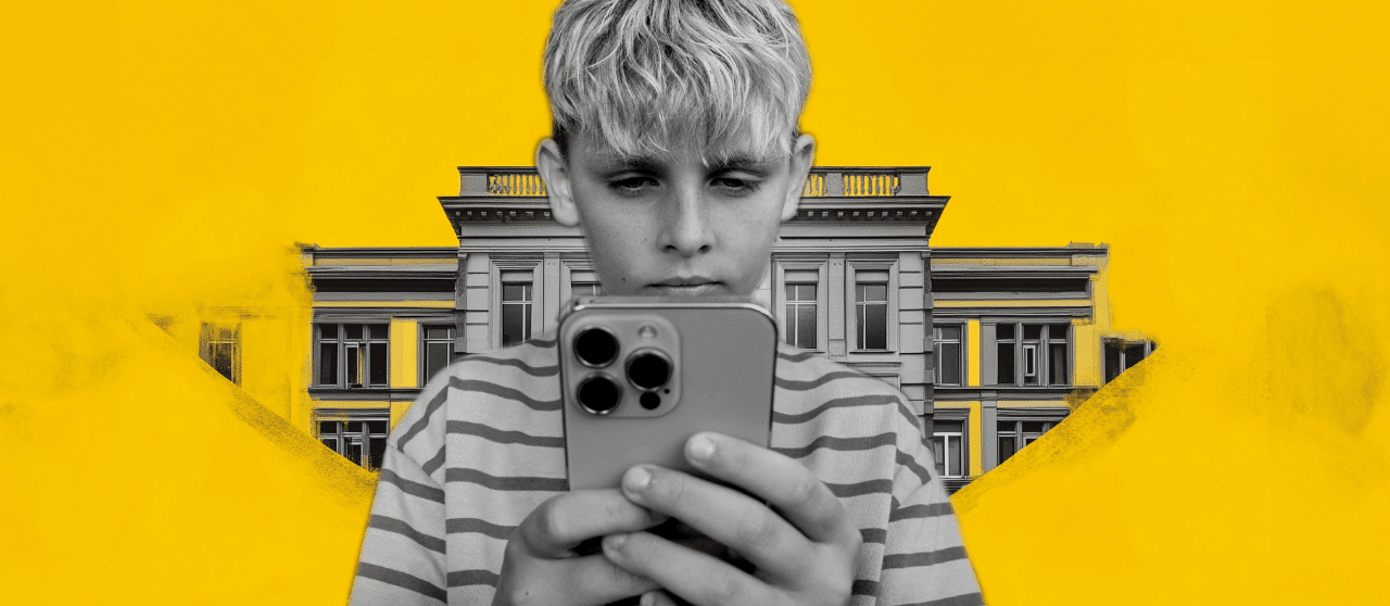 A photo of a young teen with a phone in front of a government building.