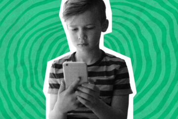 A sad boy looks on his phone.