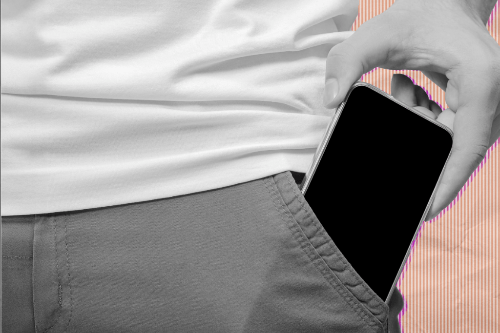 A teen putting his phone in his pocket.