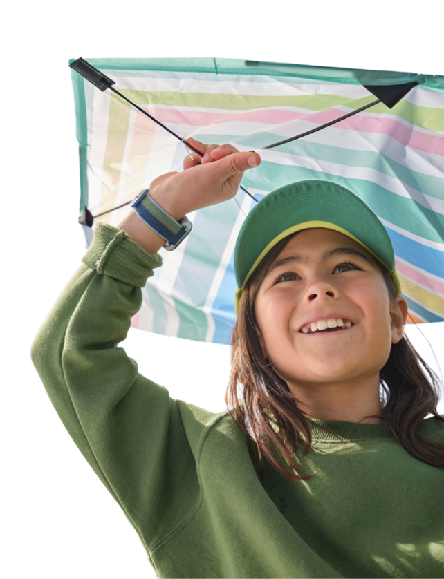 girl in a green sweatshirt holding a rainbow umbrella while wearing her gabb watch