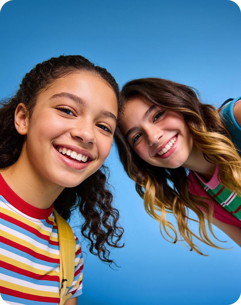 Two girls smiling on a blue background