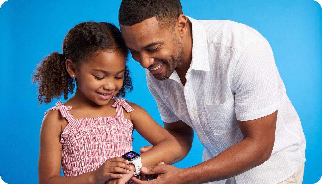 A father helping his young daughter with her Gabb watch