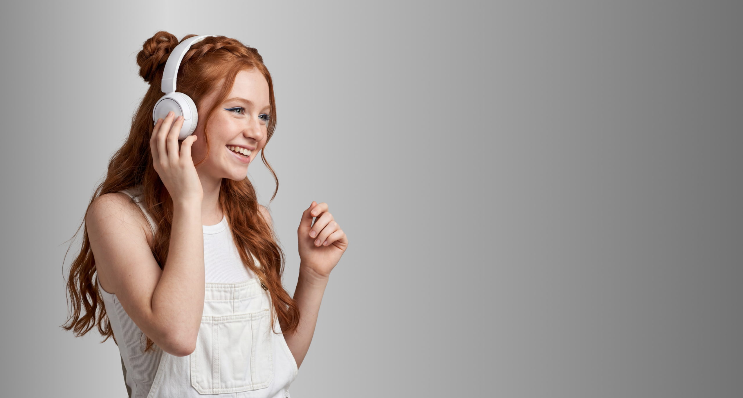 Girl smiling and listening to Gabb Music on headphones