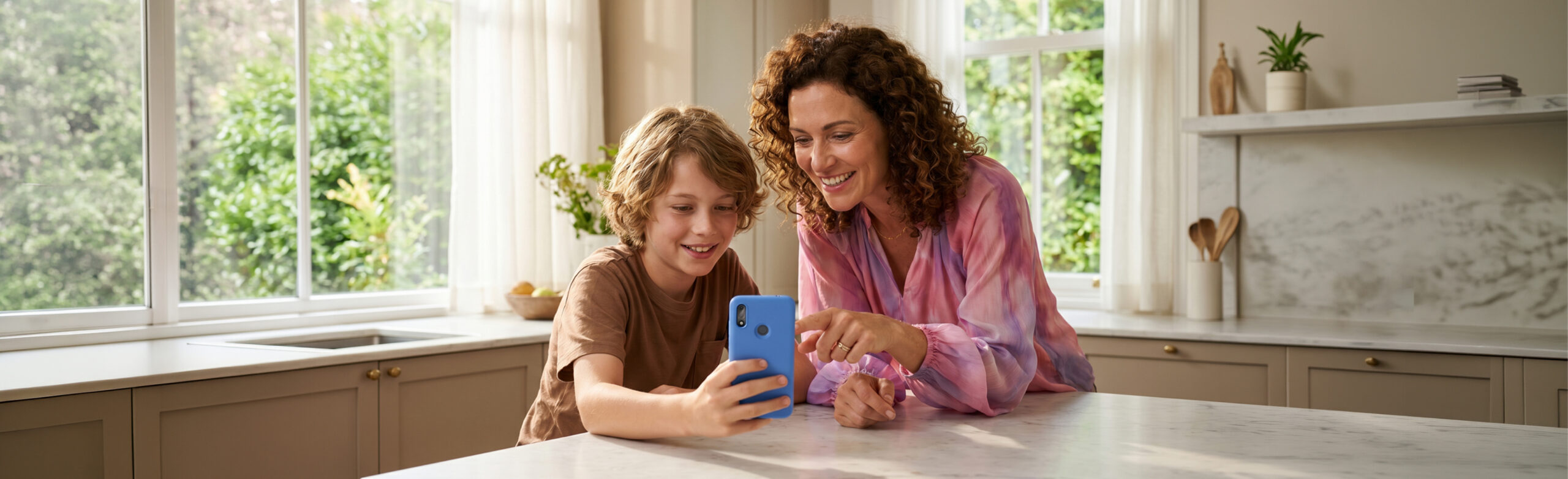 Mom and son at a kitchen counter looking at a blue Gabb phone