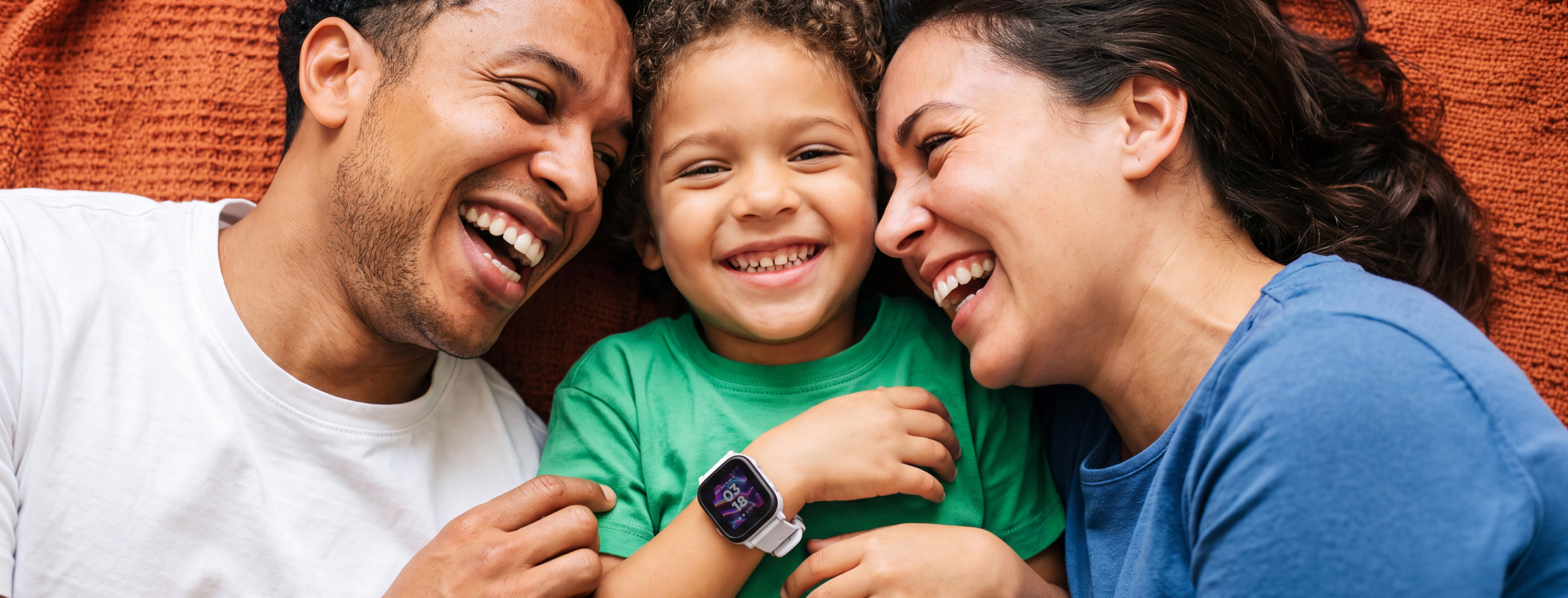 Family lying down together, child wearing a Gabb Watch